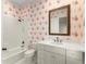 Charming bathroom with floral wallpaper, framed mirror, and a bathtub with shower at 3128 Lower Roswell Rd, Marietta, GA 30068