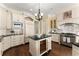 Kitchen featuring white cabinets, granite countertops, a wine cooler, and an island with a sink at 3128 Lower Roswell Rd, Marietta, GA 30068