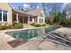 Stunning backyard pool with stone surround and steps up to a covered porch with view of the home's large arched window at 3128 Lower Roswell Rd, Marietta, GA 30068