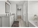 Bright bathroom features granite counters, white cabinets and tile floors leading to the bath and shower at 372 Garnet Dr, Acworth, GA 30101