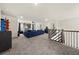 Spacious bonus room with plush carpeting, ceiling fan, and comfortable blue sectional sofa at 372 Garnet Dr, Acworth, GA 30101