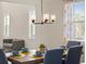 Cozy dining room with decorative chandelier, wooden table, and natural light from the windows at 372 Garnet Dr, Acworth, GA 30101