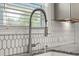 Close-up of kitchen faucet, granite countertop, and subway tile backsplash at 372 Garnet Dr, Acworth, GA 30101