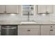 Close-up of kitchen counter with white cabinets, stylish backsplash, and stainless steel dishwasher at 372 Garnet Dr, Acworth, GA 30101