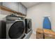 Well-organized laundry room featuring gray washer and dryer, storage cabinets, and wicker baskets at 372 Garnet Dr, Acworth, GA 30101