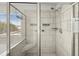 Modern bathroom shower featuring gray tiling, glass door, shower head, and corner bench at 372 Garnet Dr, Acworth, GA 30101