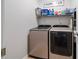 Functional laundry room equipped with modern washer and dryer, shelving and ample storage space at 3862 Memphis Dr, Suwanee, GA 30024