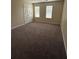 Neutral bedroom features cozy brown carpeting and natural light from two windows at 504 Harbor Lake Ct, Marietta, GA 30066