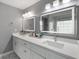 Modern bathroom with double vanity, lighted mirrors, updated hardware, and marble tile flooring at 1445 Wheatfield Dr, Lawrenceville, GA 30043