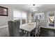 Elegant dining room with a modern chandelier, gray walls, dark floors, and bright windows for natural light at 1445 Wheatfield Dr, Lawrenceville, GA 30043