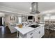 Open-concept kitchen features an island cooktop, stainless hood, white cabinets, dark floors, and a view into the living room at 1445 Wheatfield Dr, Lawrenceville, GA 30043