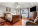Warm bedroom features a wood bed frame, dark floors, ceiling fan and natural light from a backyard window at 1445 Wheatfield Dr, Lawrenceville, GA 30043