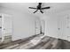 Bedroom with all white walls and trim, gray wood-look flooring and ceiling fan at 2571 Hamill Dr, Buford, GA 30519
