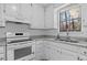 Bright kitchen features stainless appliances, stone countertops, ample white cabinetry, and a window view at 2571 Hamill Dr, Buford, GA 30519