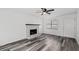 Cozy living room features a stone fireplace, ceiling fan, and modern gray flooring at 2571 Hamill Dr, Buford, GA 30519