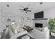 Inviting living room features a stone fireplace, stylish furniture, a ceiling fan, and an open floorplan to kitchen at 2571 Hamill Dr, Buford, GA 30519