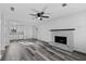 Bright living room boasts modern gray flooring, a ceiling fan, and an open floorplan leading to the kitchen at 2571 Hamill Dr, Buford, GA 30519