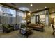 This cozy lounge space includes two green chairs, a sofa, a coffee table, and large windows at 2626 Peachtree Nw Rd # 1007, Atlanta, GA 30305