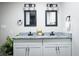 Bathroom with double vanity, granite countertops, modern lighting, and tiled mirrors at 3490 Primrose Pl, Decatur, GA 30032