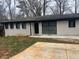 Charming single-story home with a painted brick facade and modern black trim, complemented by a spacious driveway at 3490 Primrose Pl, Decatur, GA 30032