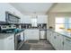 Modern kitchen featuring stainless steel appliances, granite countertops and white cabinetry and wood floors at 3490 Primrose Pl, Decatur, GA 30032