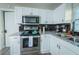 Bright kitchen featuring stainless steel appliances, granite countertops, and black tile backsplash at 3490 Primrose Pl, Decatur, GA 30032