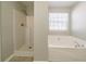 Bathroom featuring separate shower and tub with large window letting in natural light at 493 Townsend Bnd, Stockbridge, GA 30281