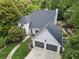 Aerial view of a light blue house and large driveway surrounded by dense green trees at 5323 Presley Pl, Douglasville, GA 30135
