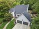 An aerial view of a meticulously maintained home with an attached two car garage surrounded by mature trees at 5323 Presley Pl, Douglasville, GA 30135