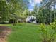 Well-manicured backyard with a pergola, lush greenery, and a house on a hill at 5323 Presley Pl, Douglasville, GA 30135