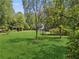 Spacious backyard featuring well-maintained lawn, mature trees, and a wooden pergola at 5323 Presley Pl, Douglasville, GA 30135
