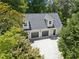 Aerial view of a three-car garage with a large driveway surrounded by lush greenery at 5323 Presley Pl, Douglasville, GA 30135