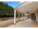 Covered back patio with white pillars overlooking the large yard and mature trees at 5480 Beaver Ridge Dr, Cumming, GA 30040