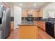 Well-lit kitchen featuring granite countertops, stainless steel refrigerator, and wood cabinets at 5480 Beaver Ridge Dr, Cumming, GA 30040