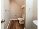 Bathroom featuring toilet, wood-look floors, and a sink at 6797 Mahonia Pl, Lithonia, GA 30038