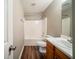 Standard bathroom with a shower-tub combo, wood-look flooring, and a single sink vanity at 6797 Mahonia Pl, Lithonia, GA 30038