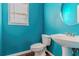 A half bathroom features a modern pedestal sink, toilet, and a round mirror at 1011 Buckhorn Bnd, Locust Grove, GA 30248