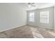 A bright bedroom with carpet, two windows, white walls, and natural light at 1011 Buckhorn Bnd, Locust Grove, GA 30248
