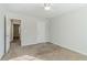 Carpeted bedroom with open door to hallway, ceiling fan, and white walls at 1011 Buckhorn Bnd, Locust Grove, GA 30248