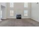 Bright living room with a fireplace, large windows, and neutral carpeting at 1011 Buckhorn Bnd, Locust Grove, GA 30248