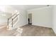 Well-lit living room with plush carpeting and views of the staircase at 1011 Buckhorn Bnd, Locust Grove, GA 30248