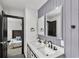 Updated bathroom featuring a dual vanity with modern fixtures, framed mirrors, and a view into the bedroom at 4041 Blanton Sw Ave, Atlanta, GA 30331