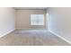 A bedroom with neutral walls, carpet flooring, and a window with blinds, providing a cozy and well-lit space at 7434 Rudder Cir, Fairburn, GA 30213