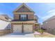 Two-story brick home featuring an attached two-car garage and a well-maintained front yard at 7434 Rudder Cir, Fairburn, GA 30213