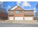 Brick townhome with three garage doors and traditional architecture under a blue sky at 805 Pleasant Hill Rd # 171, Lilburn, GA 30047