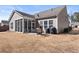 Rear view of home with screened porch, patio with seating, and lawn at 131 Riverside Ln, Woodstock, GA 30188