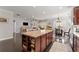 Open-concept kitchen with a granite-topped island, dark wood cabinets, and a view of the living room at 131 Riverside Ln, Woodstock, GA 30188