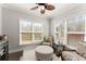 Cozy sitting room with two windows, patterned chairs, ottoman, hardwood floors, and neutral paint at 131 Riverside Ln, Woodstock, GA 30188