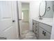 Modern bathroom with double vanity, grey cabinets, matte black hardware and stone-look floors at 255 Olde Oak Dr, Jonesboro, GA 30238
