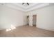 Spacious bedroom with tray ceiling, light wood floors, and a walk-in closet at 255 Olde Oak Dr, Jonesboro, GA 30238